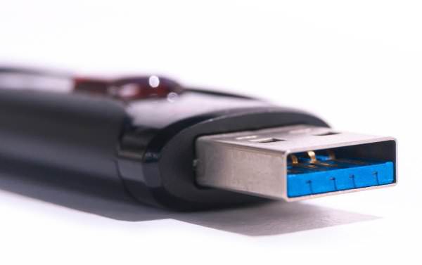 Hand insert USB drive into laptop USB port.