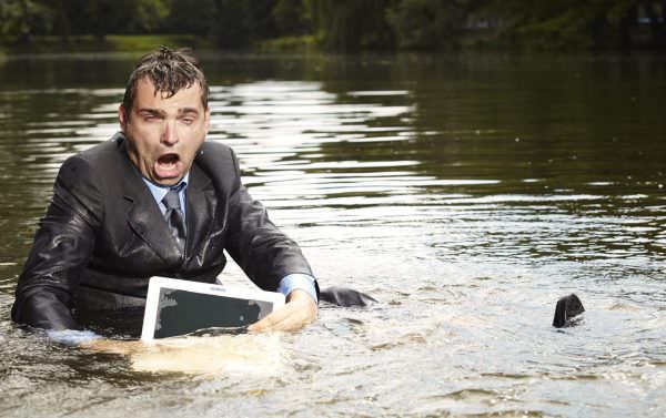 Man with laptop drenched in water