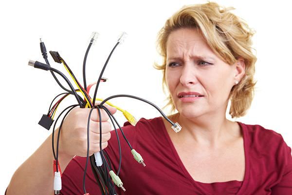 Woman with a handful of cables looking confused.
