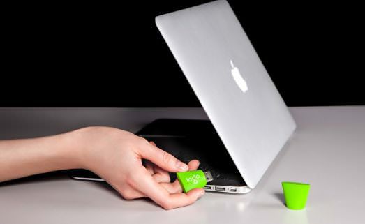 Plugging a green USB drive into a laptop